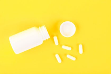 دانلود عکس بطری پزشکی پلاستیکی سفید با قرص کپسول روی الف