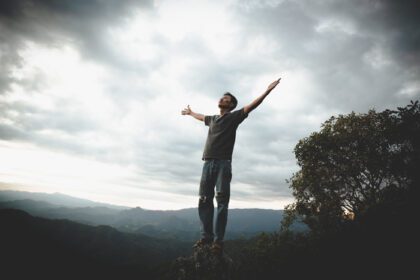 دانلود عکس مردی در حال نماز خواندن در کوهستان با دستان بالا سفر سبک زندگی