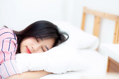 دانلود عکس پرتره زن جوان آسیایی زیبا که در رختخواب دراز کشیده است