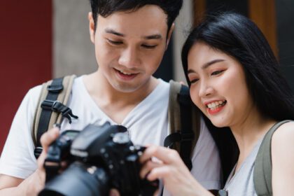 دانلود عکس زوج آسیایی مسافر با استفاده از دوربین برای گرفتن عکس در حالی که