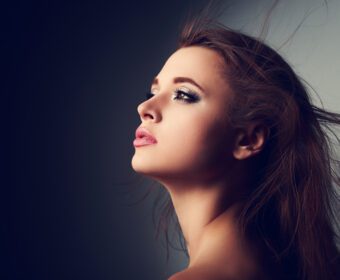 دانلود عکس پروفایل زیبای آرایشی زن با موهای بلند که با امید روی روشن در پس زمینه تیره به بالا نگاه می کند