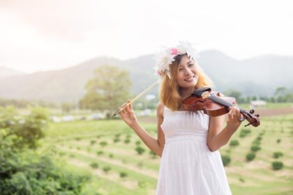 دانلود عکس زن جوان هیپستر نوازنده در حال نواختن ویولن در طبیعت