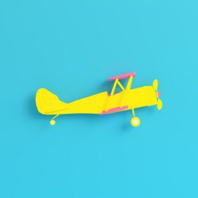 دانلود عکس هواپیمای دوباله زرد در پس زمینه آبی روشن در رنگ های پاستلی