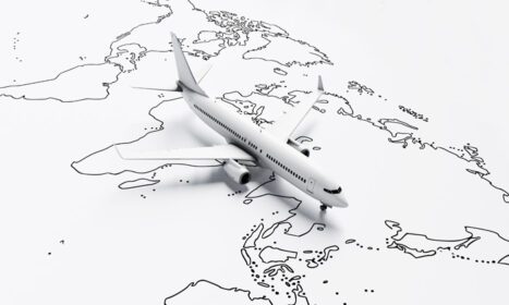 دانلود عکس پرواز هواپیما در بالای کاغذ سفید نقشه سفر جهان