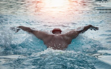 دانلود عکس مرد ورزشی شناگر با کلاه نفس در حال اجرای پروانه