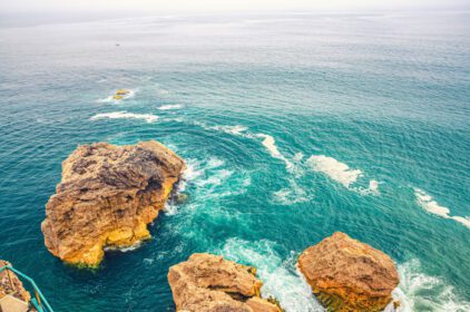 دانلود عکس بالا نمای هوایی از برخورد امواج با صخره ها و صخره های کوچک
