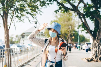 دانلود عکس راه رفتن زن جوان آسیایی مسافر ماسک صورت برای