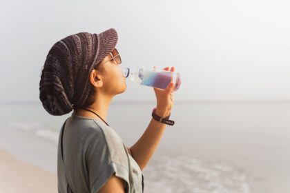 دانلود عکس زن توریستی در حال آبرسانی به آب آشامیدنی از بطری