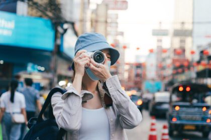 دانلود عکس زن جوان آسیایی مسافر زنان با استفاده از دوربین