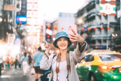دانلود عکس سلفی زن جوان آسیایی مسافر با تلفن همراه