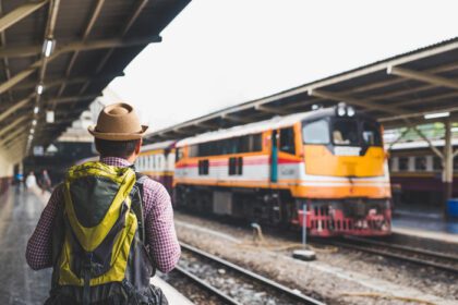 دانلود عکس مرد جوان مسافر در سکوی ایستگاه قطار مفهوم سفر