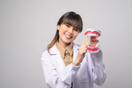دانلود عکس دندانپزشک زن جوان با لبخند روی استودیو پس زمینه سفید
