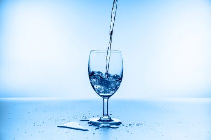 دانلود عکس مجموعه آب پاش در لیوان شراب جدا شده در پس زمینه آبی