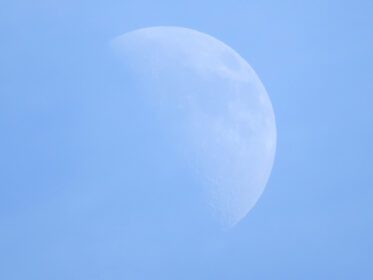 دانلود عکس نیمه ماه در آسمان آبی در طول روز