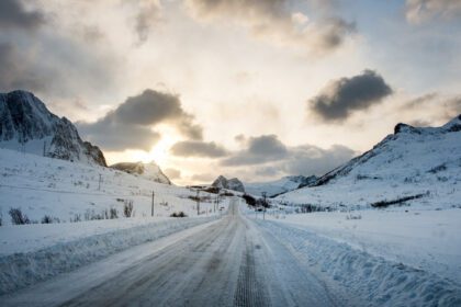 دانلود عکس جاده برفی کثیف با نور خورشید روی کوه