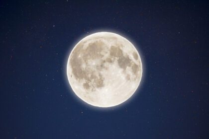 دانلود عکس درخشش رنگین کمانی ماه کامل در آسمان پرستاره شب