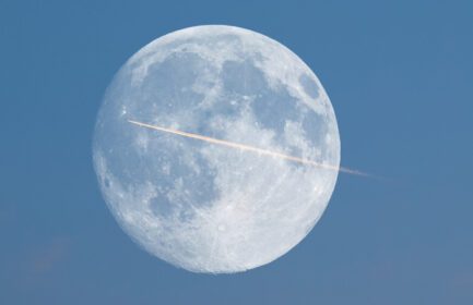 دانلود عکس دنباله هواپیما در مقابل ماه کامل دیده شده با تلسکوپ