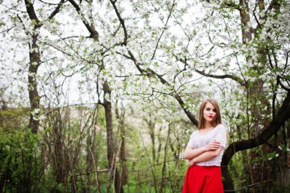 دانلود عکس پرتره دختر زیبا با لب های قرمز در شکوفه بهاری