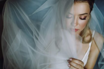 دانلود عکس پرتره عروس بلوند خیره کننده با چشمان عمیق پنهان شده در زیر حجاب آبی