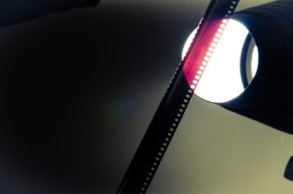 دانلود عکس رول قدیمی نگاتیو که در مقابل نور نگه داشته شده قرمز را نشان می دهد