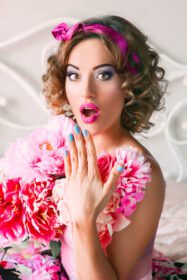 دانلود عکس پرتره زن جوان با لباس رنگارنگ با گل روی آن