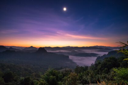 دانلود عکس دیدگاه نور خورشید بر فراز کوه با ماه در سپیده دم