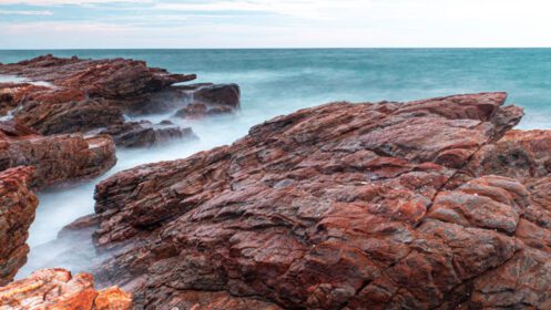 دانلود عکس نوردهی طولانی از دریا با ماهیت موجی صاف و صخره ای