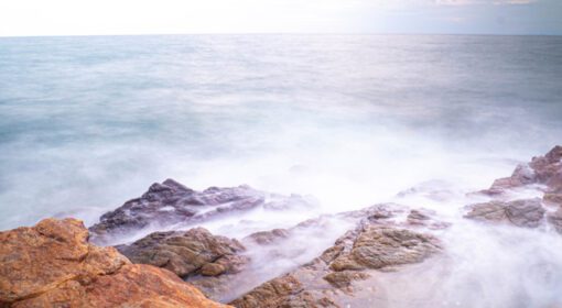 دانلود عکس نوردهی طولانی از دریا با ماهیت موجی صاف و صخره ای