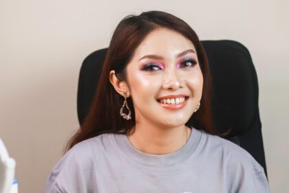 دانلود عکس خندان زن جوان آسیایی با آرایش نشسته روی یک