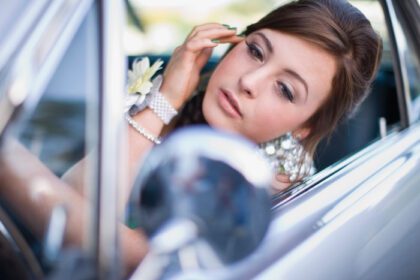 دانلود عکس دختر نوجوان در حال بررسی آرایش در ماشین