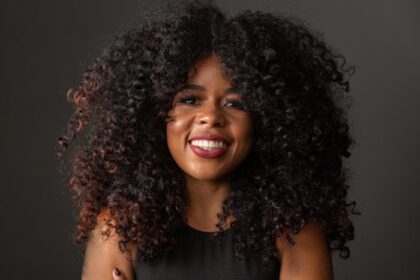 دانلود عکس زن جوان آفریقایی-آمریکایی با موهای مجعد که به دوربین نگاه می کند