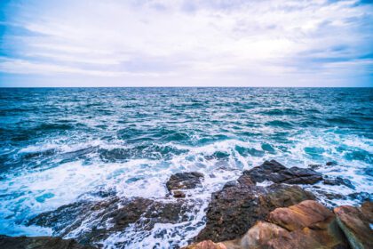دانلود عکس دریا با موج صاف و صخره منظره طبیعت دریا