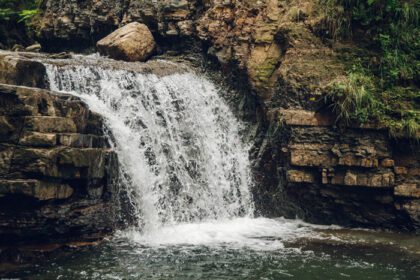 دانلود عکس آبشار کوچک با دریاچه ای در میان صخره ها و جنگل