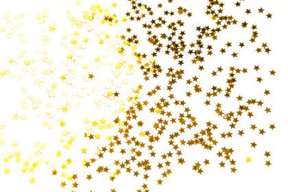 دانلود عکس پولک های طلایی به شکل ستاره هایی که روی سفید می درخشند